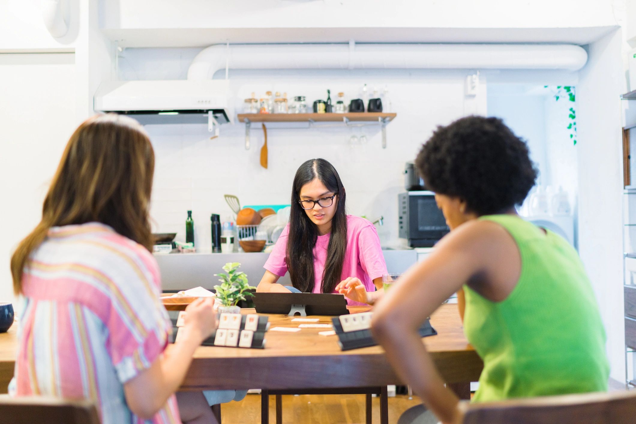 Friends gathered around a table playing a board game